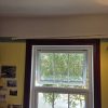 Before Sagging metal curtain rail pulling away from the drywall fixings inside a rental property lounge before a maintenance job