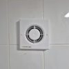 After Brand new Manrose extractor fan cleanly installed and flush mounted on a white tiled bathroom wall after an electrical jo
