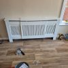 Pristine Chelsea white radiator guard shelf completely constructed and fitted flush against a living room wall surface