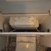 Newly installed hidden toilet cistern tucked inside a clean bathroom back to wall cabinet following a plumbing replacement