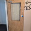 Completed fire door repair featuring a newly fitted Georgian wired safety glass vision panel pane held securely in place