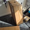 Multiple flat pack boxes containing VOGREX console tables stacked together on the floor before an assembly job