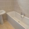 Newly sealed acrylic bath corner joint featuring a smooth immaculate bead of anti-mould sanitary caulk lines