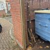 New wooden gate post securely attached to the existing brick wall with replacement anchor fixings, ready for the gate to be rehung.
